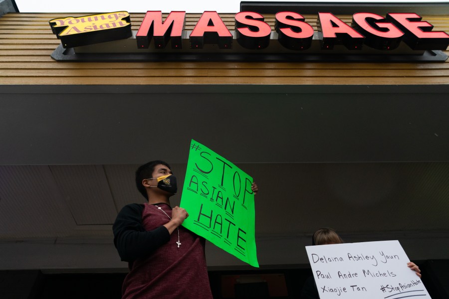 Jesus Estrella holds a sign of solidarity outside Youngs Asian Massage where four people were shot and killed on March 17, 2021 in Acworth, Georgia. (Elijah Nouvelage/Getty Images)