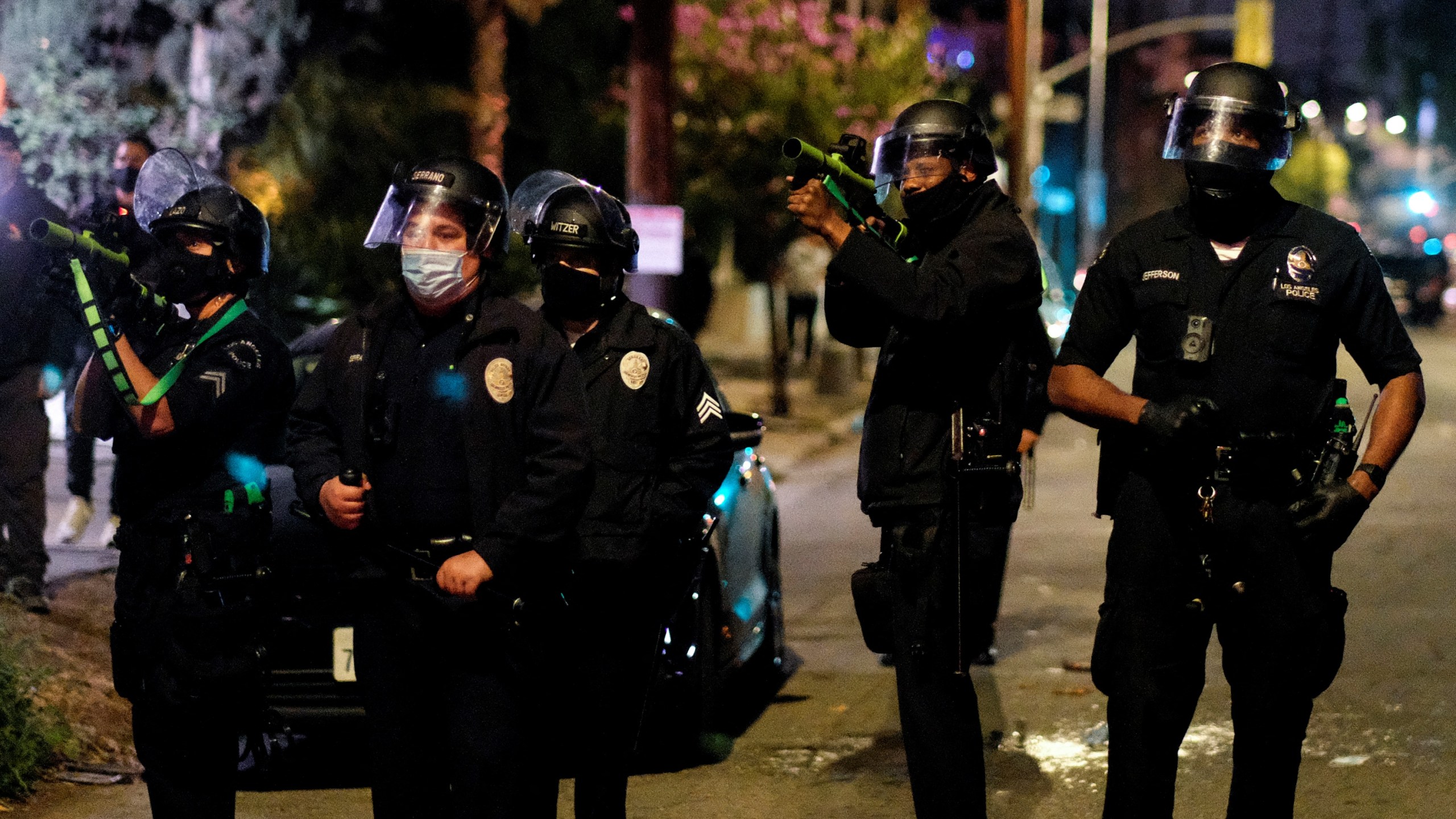 Police point pepper balls guns toward activists and supporters of residents of a homeless encampment at Echo Park Lake in Los Angeles late on March 24, 2021, ahead of a clean-up of the encampment. (RINGO CHIU/AFP via Getty Images)