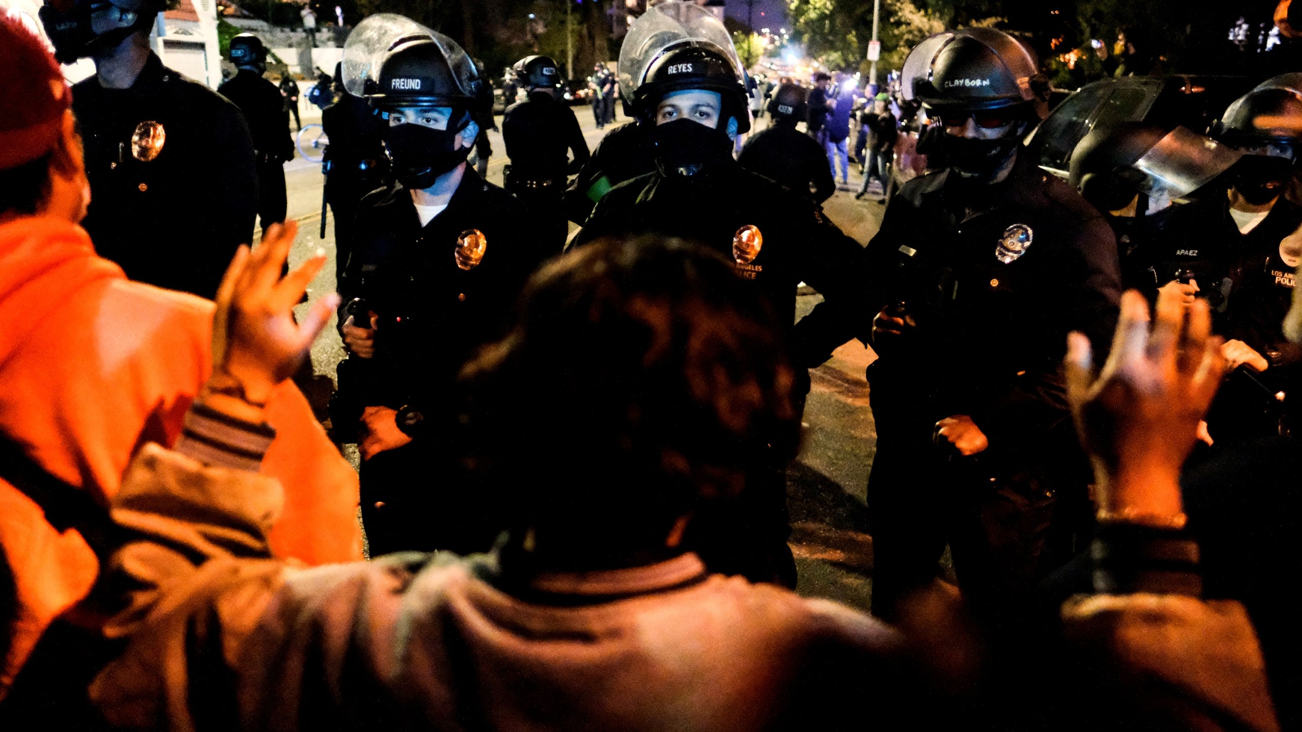 Activists and supporters of residents of a homeless encampment confront police at Echo Park Lake in Los Angeles late on March 24, 2021, ahead of a planned and announced clean-up of the encampment. (Ringo Chiu / AFP / Getty Images)