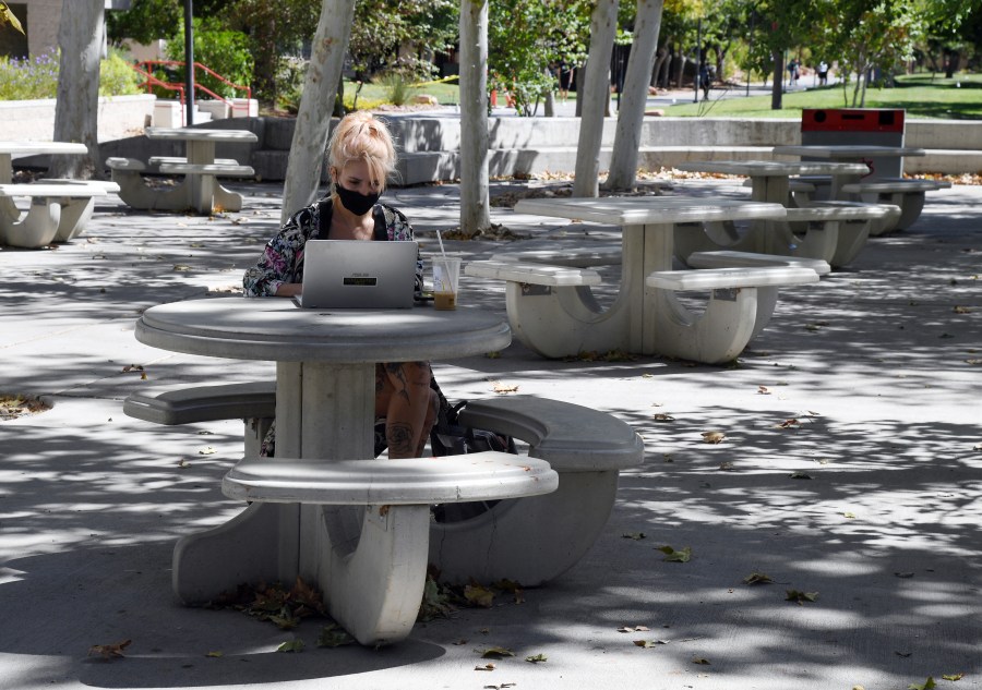 UNLV junior student Kristina Eichblatt works on a laptop in a courtyard on campus before attending a class at UNLV amid the spread of the coronavirus (COVID-19) on September 9, 2020 in Las Vegas, Nevada. (Photo by Ethan Miller/Getty Images)