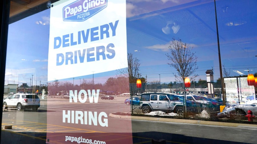 A "Now Hiring" sign is displayed, Thursday, March 4, 2021, in Salem, N.H. After a year of ghostly airports, empty sports stadiums and constant Zoom meetings, growing evidence suggests that the economy is strengthening. (AP Photo/Elise Amendola)