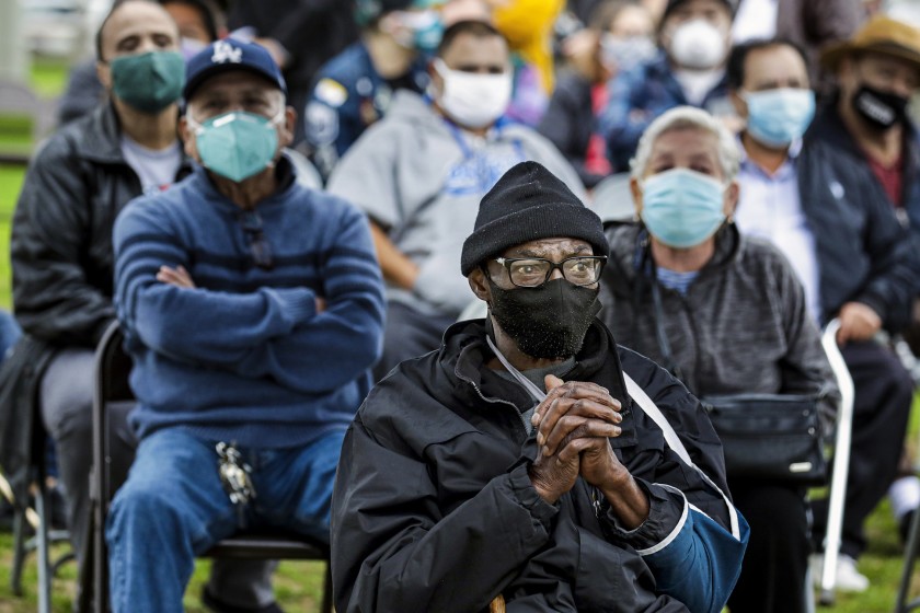 Anthony Angulo, 71, center, waits for his turn to get a COVID-19 vaccine shot at a mobile vaccination site at South Park Recreation Center on Feb. 9, 2021. (Irfan Khan/ Los Angeles Times)