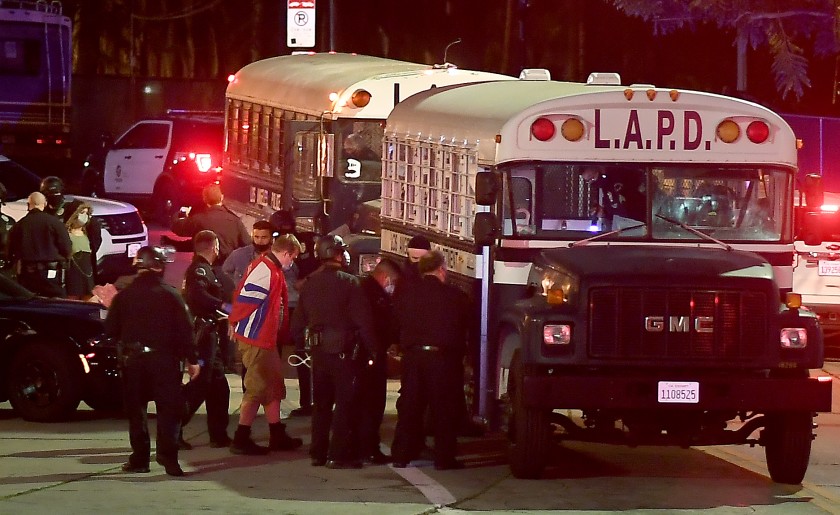 Protesters board a Los Angeles Police Department bus after being arrested in Echo Park on March 25, 2021. (Wally Skalij / Los Angeles Times)