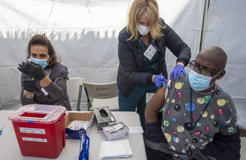 Nurse Nili Steiner administers a vaccine to Henry Fredricks, right, at a pop-up vaccination clinic in Los Angeles.(Brian van der Brug / Los Angeles Times)