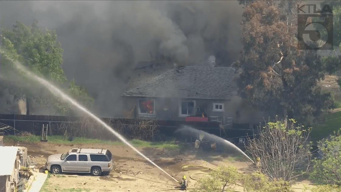 Firefighters work to extinguish flames after a reported explosion in Ontario on March 16, 2021. (KTLA)