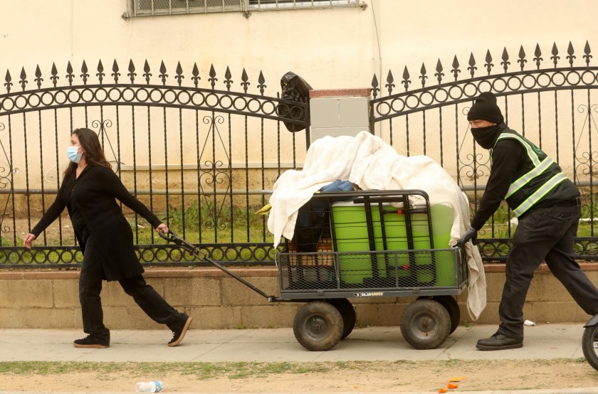 A woman helps remove the belongings of a friend who had been living in Echo Park on Thursday.(Genaro Molina / Los Angeles Times)