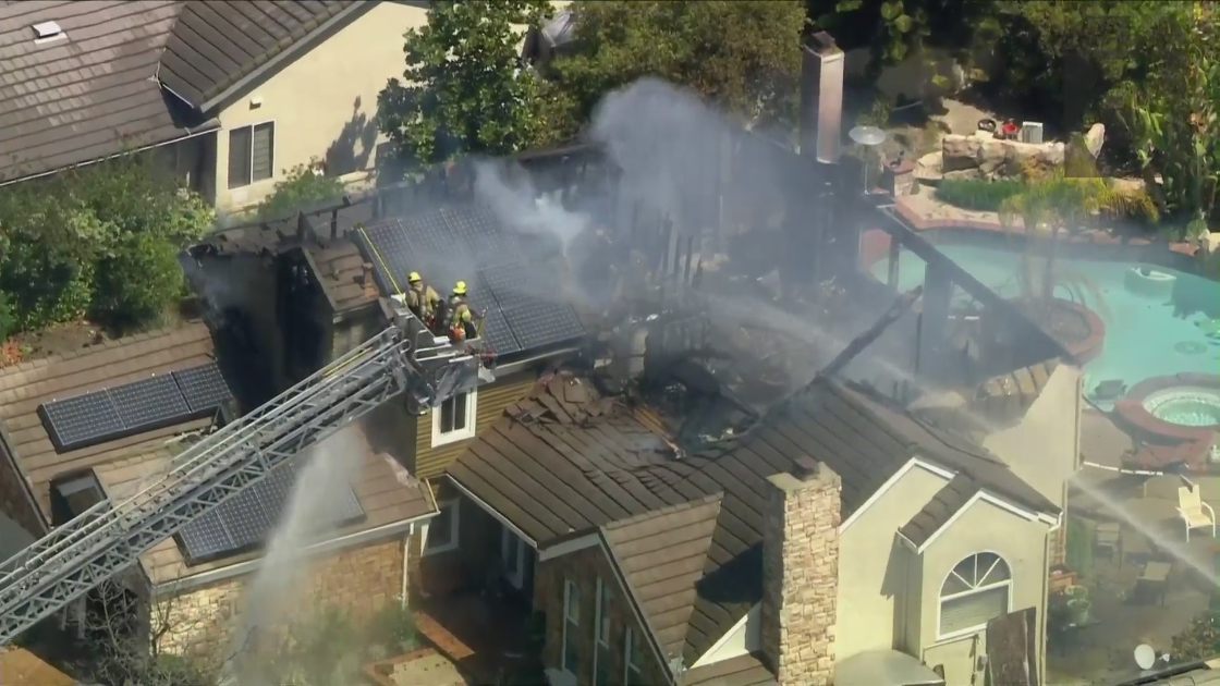 Orange County firefighters work to put out a blaze at a home in Laguna Hills on March 31, 2021. (KTLA)