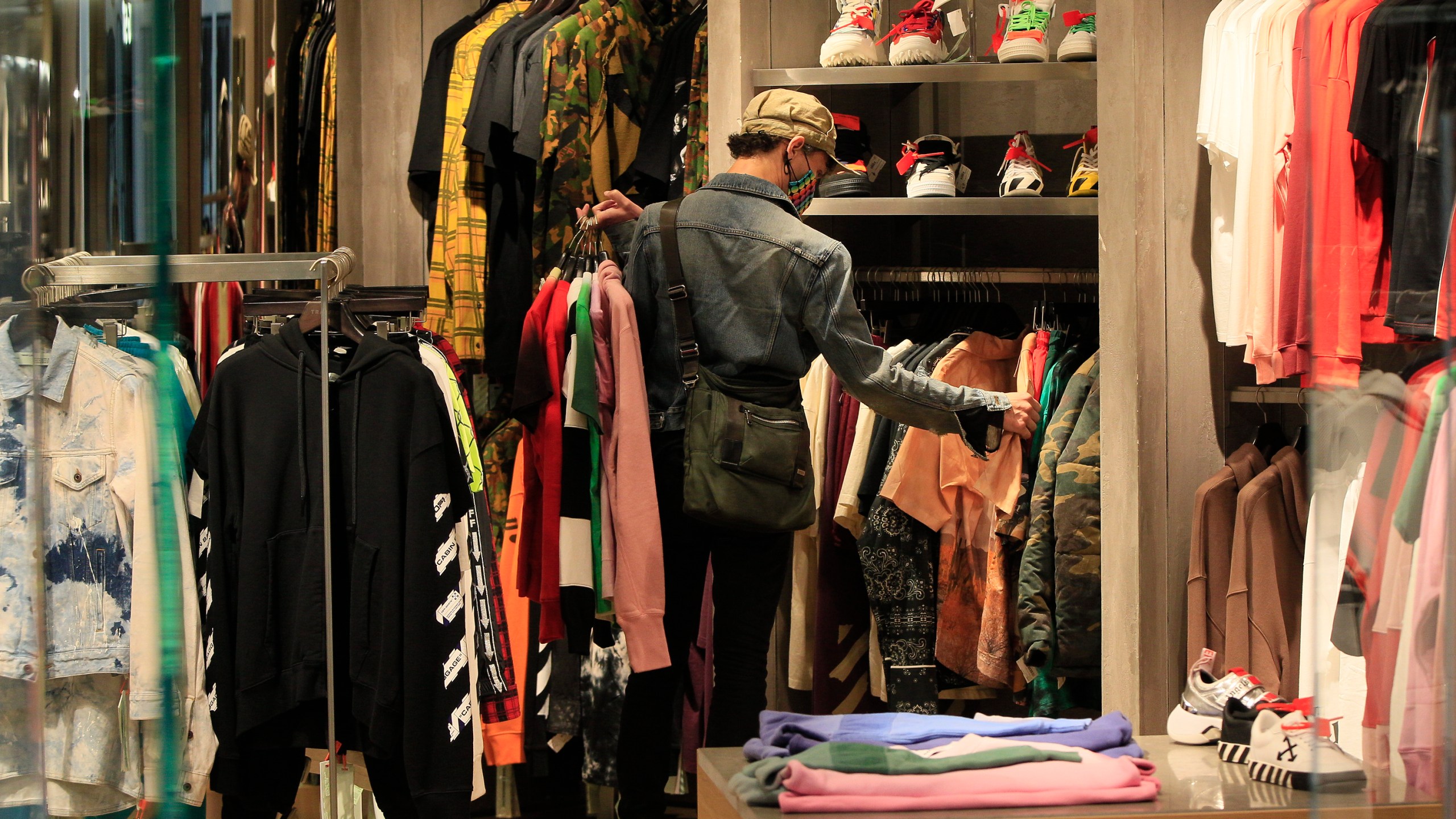 A manager at a boutique sets up new clothes for the store opening of Beverly Center shopping mall in Los Angeles on May 29, 2020. (AP Photo/Damian Dovarganes)