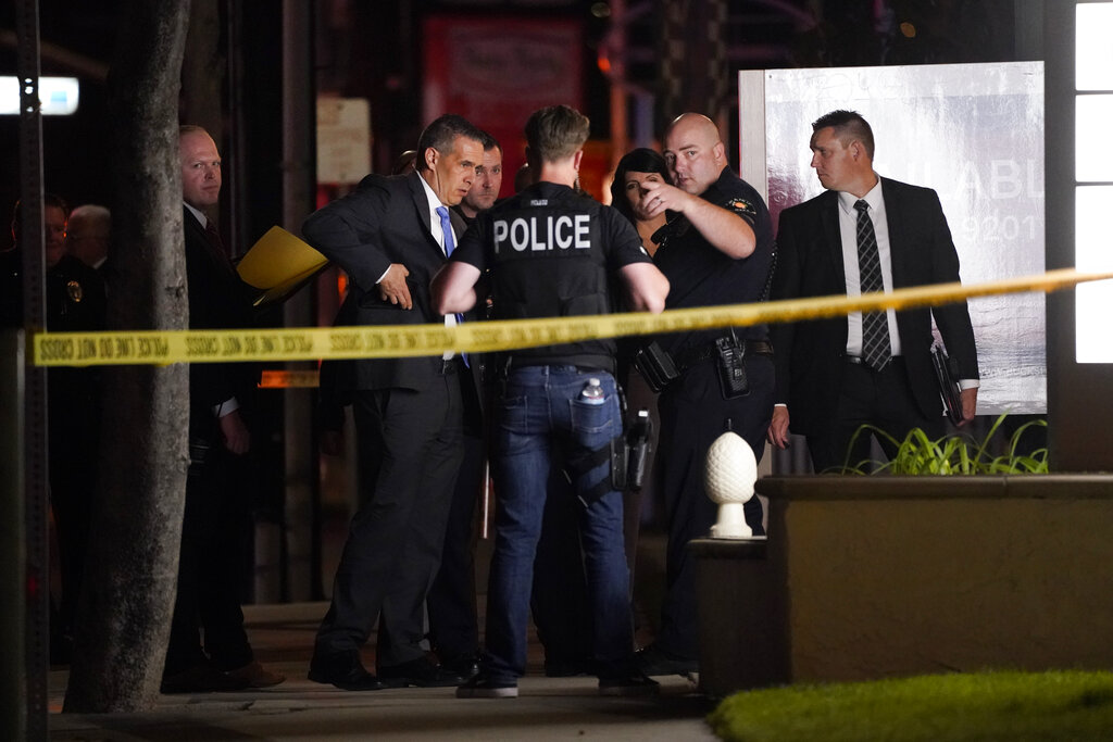 Investigators gather outside an office building where a shooting occurred in Orange, Calif., Wednesday, March 31, 2021. (AP Photo/Jae C. Hong)