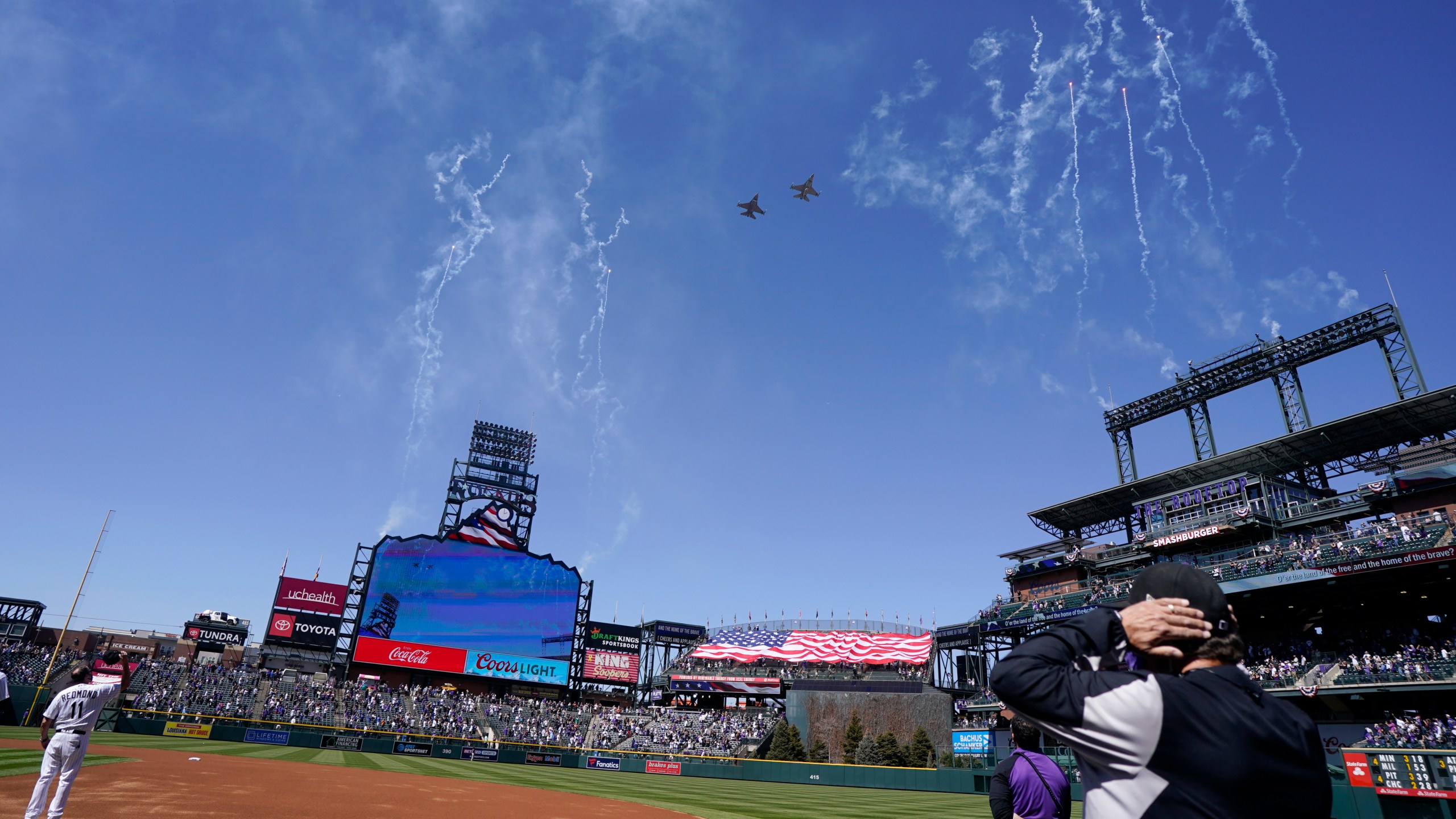 Two F-16 jets from Buckley Air Force Base in Aurora, Colo., fly over Coors Field before a baseball game between the Los Angeles Dodgers and the Colorado Rockies on opening day, Thursday, April 1, 2021, in Denver. (AP Photo/David Zalubowski)