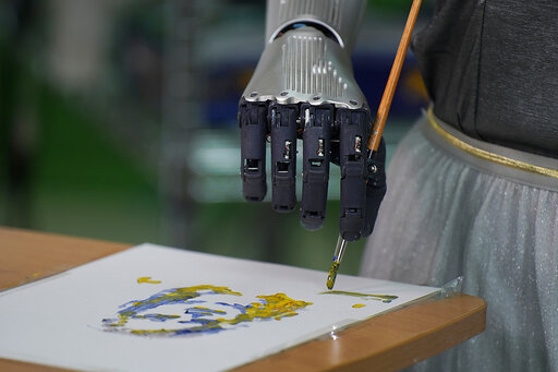 Sophia uses a brush to paint at Hanson Robotics studio in Hong Kong on March 29, 2021. (AP Photo/Vincent Yu)