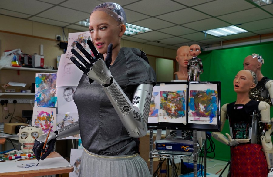 Sophia uses a brush to paint at Hanson Robotics studio in Hong Kong on March 29, 2021. (AP Photo/Vincent Yu)