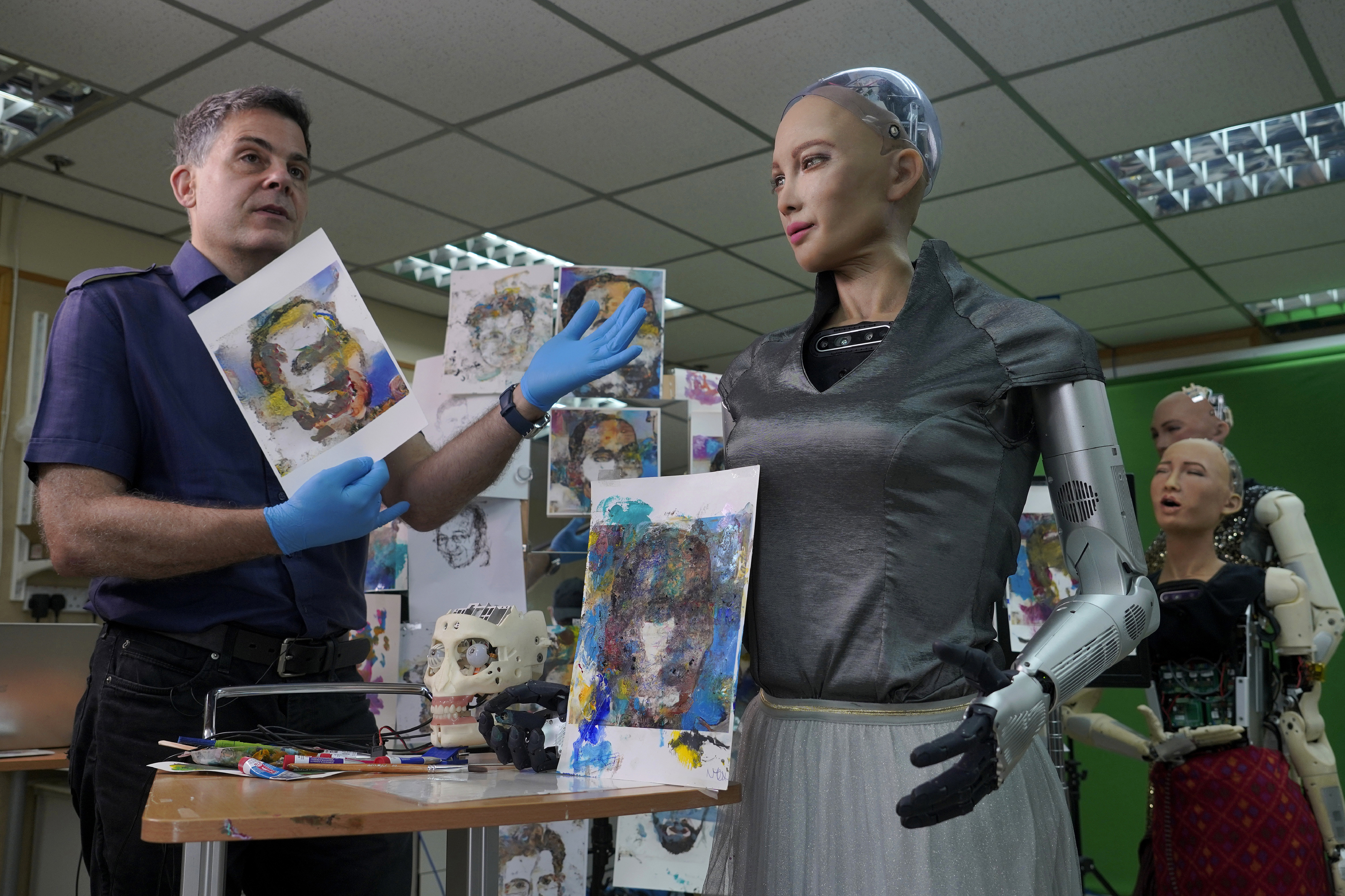 David Hanson, left, creator of Sophia, shows a work of Sophia at his studio in Hong Kong on March 29, 2021. (AP Photo/Vincent Yu)