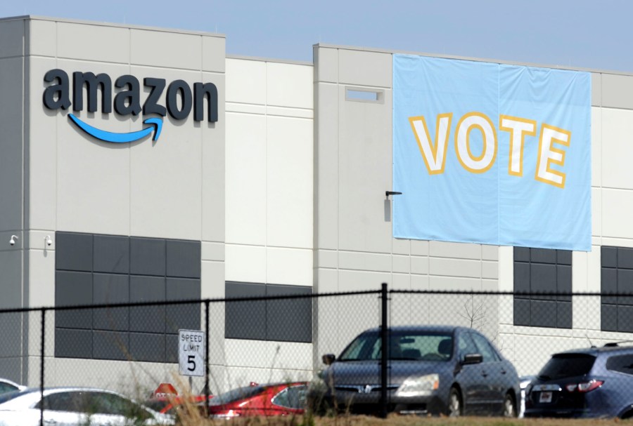 In this Tuesday, March 30, 2021 file photo, a banner encouraging workers to vote in labor balloting is shown at an Amazon warehouse in Bessemer, Ala. (AP Photo/Jay Reeves, File)