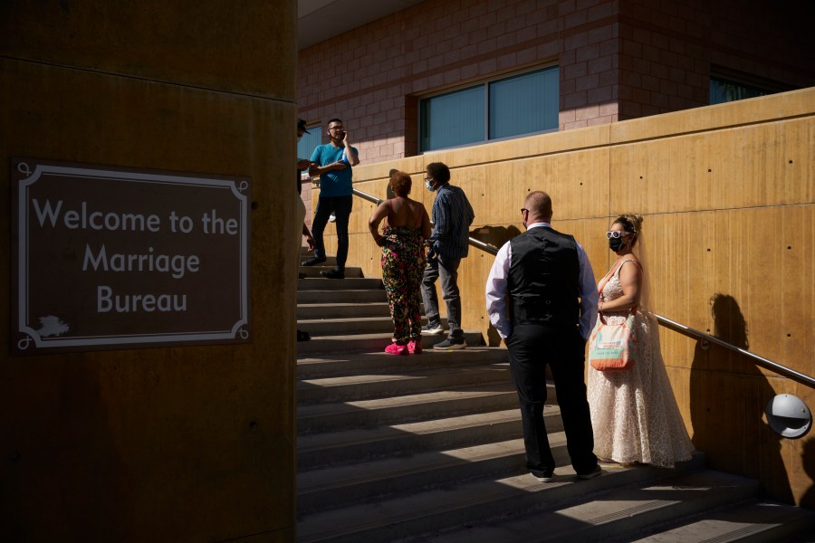 Couples wait in line for marriage licenses at the Marriage License Bureau, Friday, April 2, 2021, in Las Vegas. (AP Photo/John Locher)