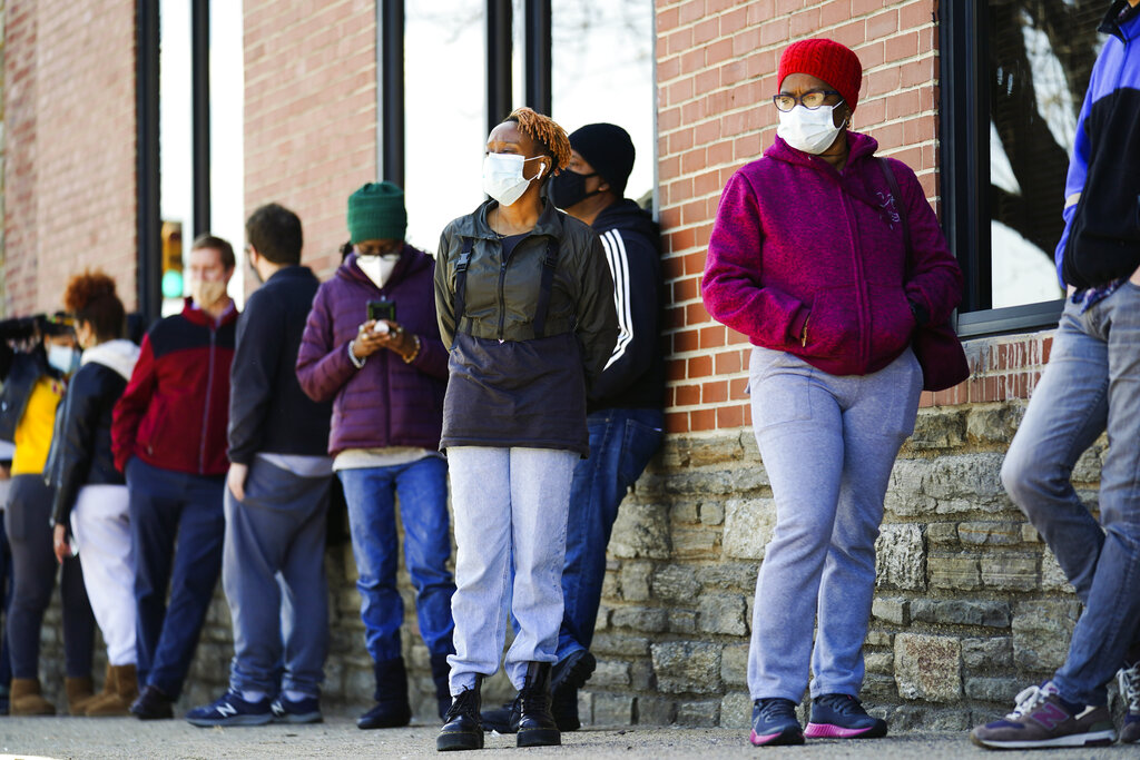 In this March 29, 2021, file photo, people wearing face masks as a precaution against the coronavirus wait in line to receive COVID-19 vaccines at a site in Philadelphia. AP Photo/Matt Rourke, File)