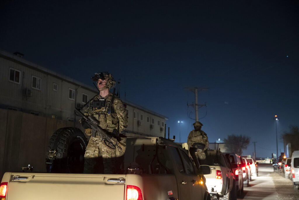 In this Nov. 28, 2019, file photo armed soldiers stand guard in the motorcade for President Donald Trump speaks during a surprise Thanksgiving Day visit to the troops at Bagram Air Field, Afghanistan. (AP Photo/Alex Brandon, File)