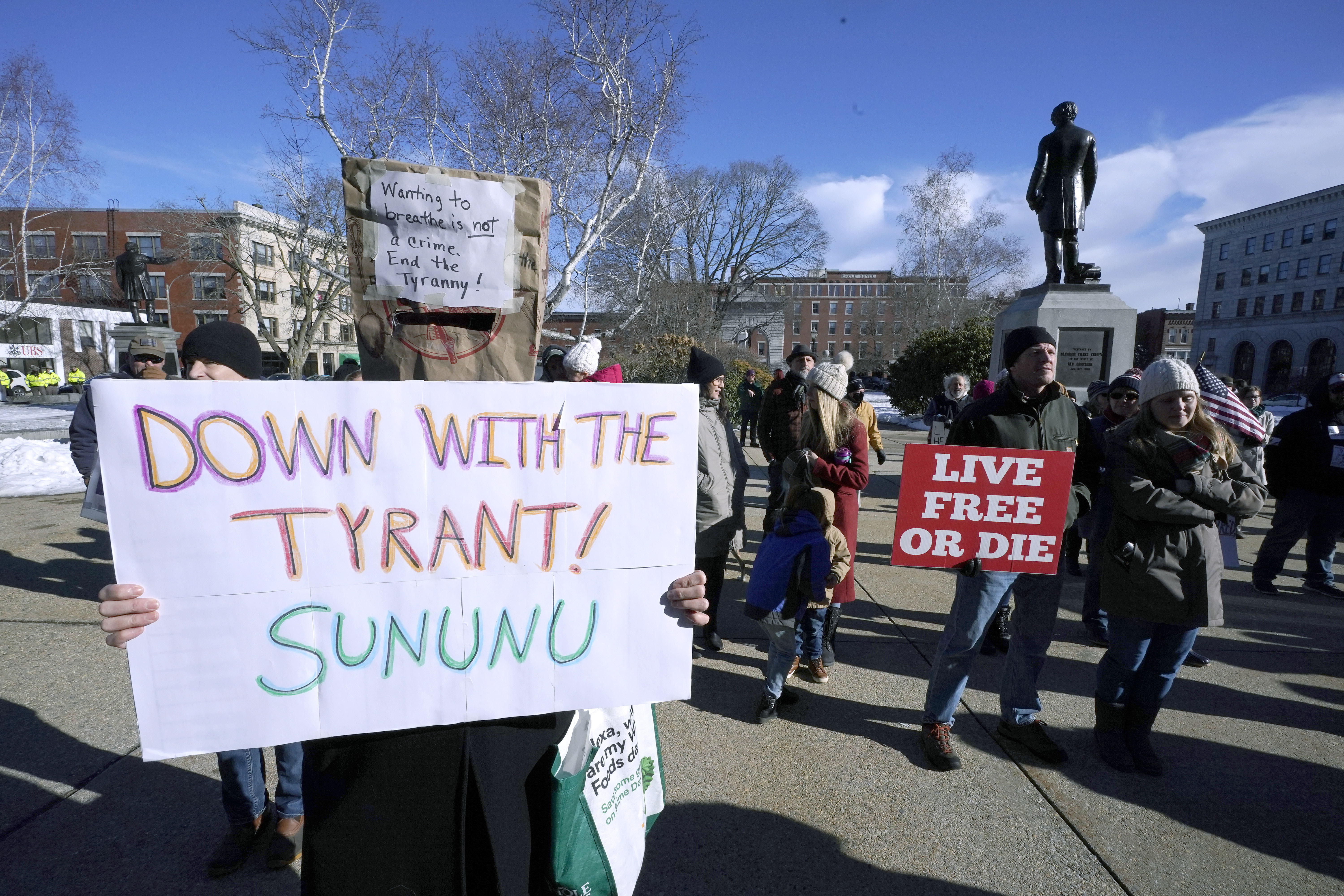 In this Thursday, Jan. 7, 2021 file photo, people protest outside the Statehouse in Concord, N.H., as Gov. Chris Sununu is inaugurated at noon for his third term as governor. A measure that recently passed New Hampshire's Republican-led House would prohibit governors from indefinitely renewing emergency declarations, as Sununu has done every 21 days for the past year. It would halt emergency orders after 30 days unless renewed by lawmakers. (AP Photo/Charles Krupa)