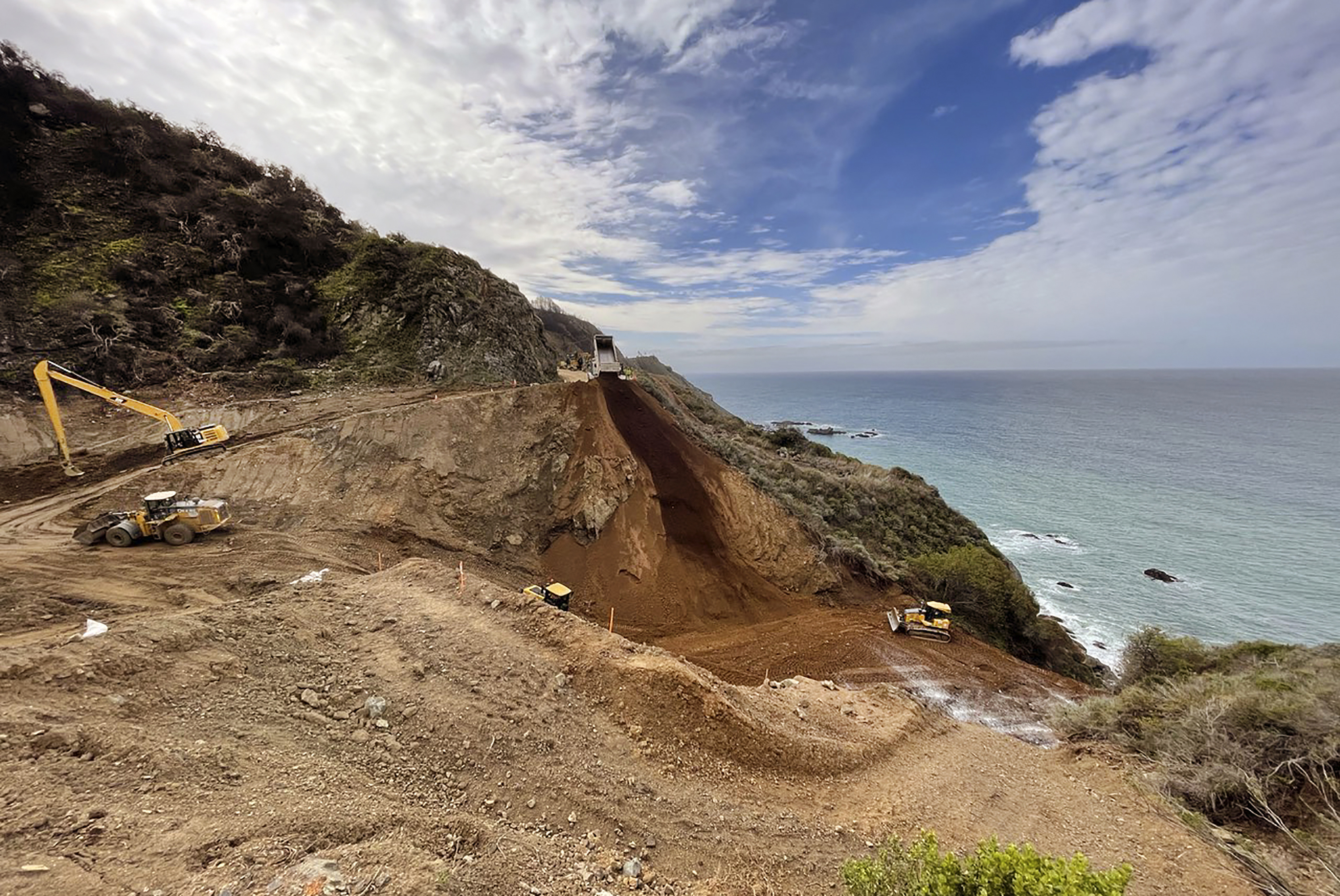 In this April 8, 2021, photo provided by the California Department of Transportation, a Caltrans construction crew repairs a section of Highway 1 along the Pacific Ocean in Big Sur, that was washed away during a winter storm on Jan. 28, 2021. The stretch of road is expected to reopen by April 30, 2021, because work to repair the huge piece of roadway that crumbled during a storm is nearly two months ahead of schedule, the California Department of Transportation announced Thursday, April 8. (Caltrans District 5 via AP)