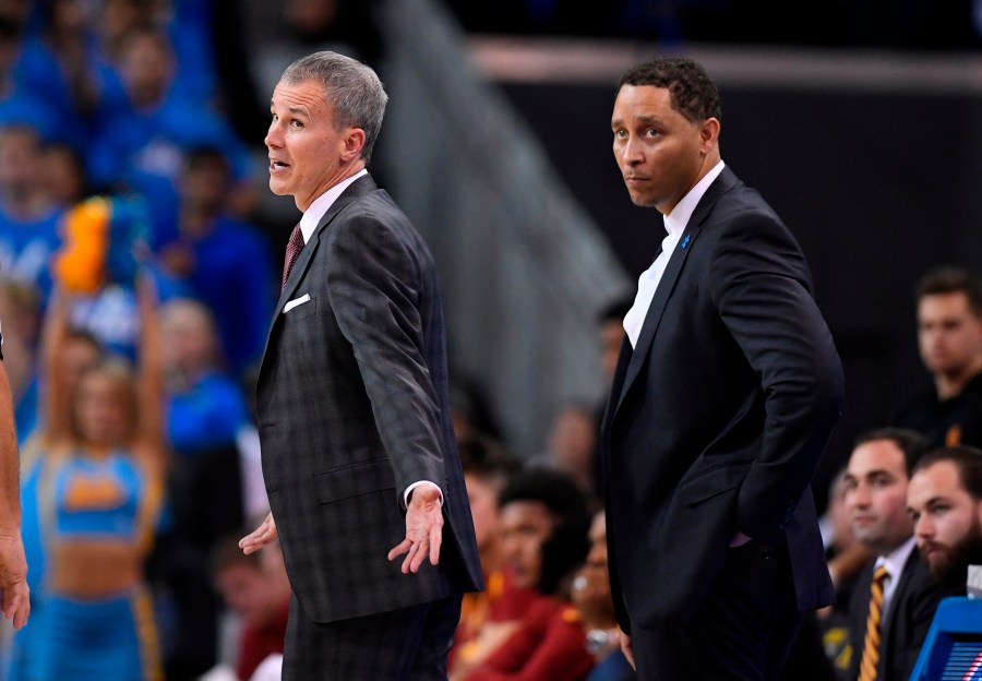 In this Feb. 18, 2017, file photo, Southern California head coach Andy Enfield, left, talks to officials as assistant coach Tony Bland stands behind him during the second half of an NCAA college basketball game against UCLA, in Los Angeles. The NCAA hit Southern California’s men's basketball program with two years’ probation and a $5,000 fine as the result of a former assistant who violated NCAA ethical conduct rules when he accepted a bribe to steer players to a business management company. (AP Photo/Mark J. Terrill, File)