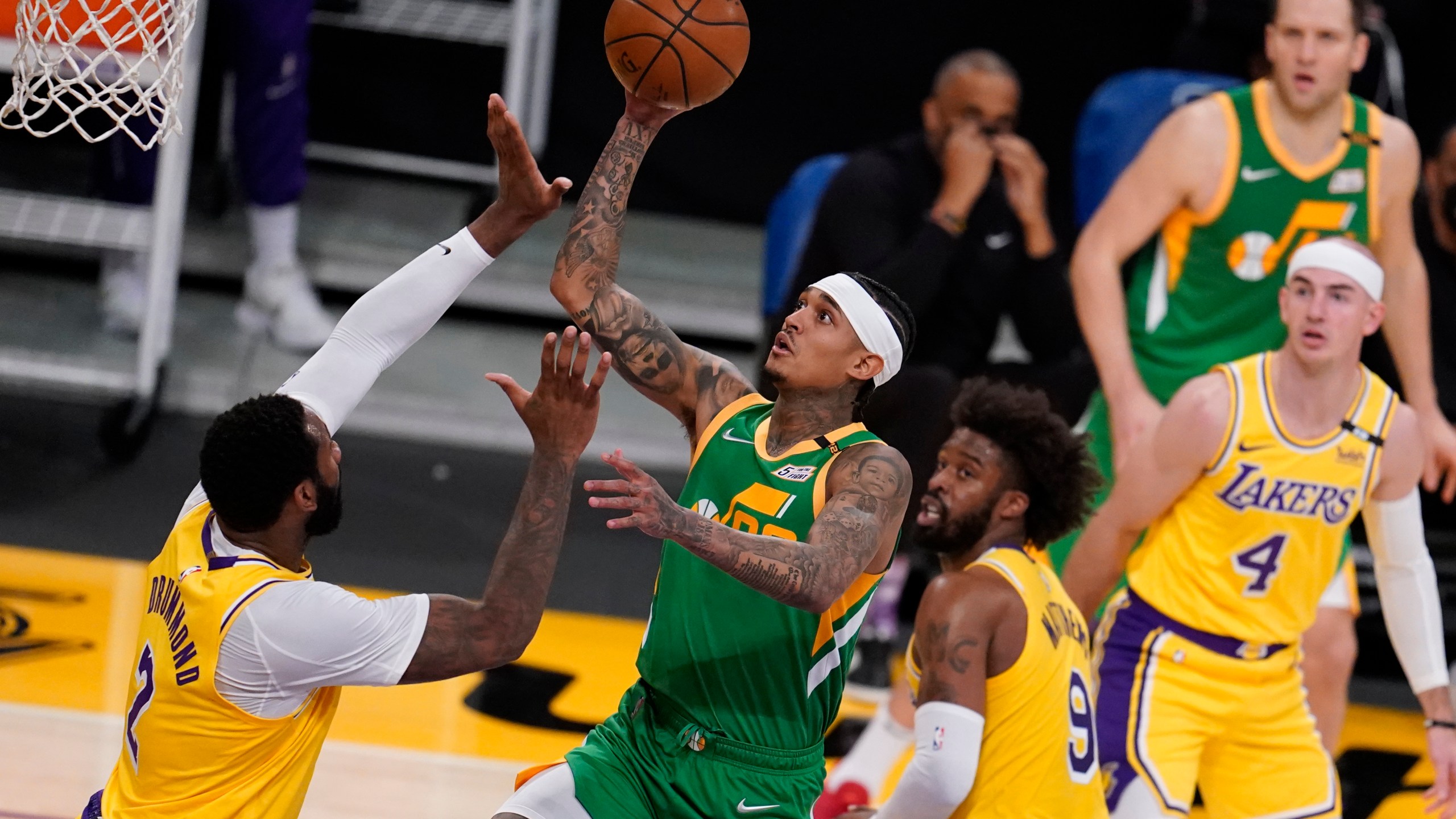 Utah Jazz guard Jordan Clarkson, center, shoots over Los Angeles Lakers center Andre Drummond, left, during the first half of an NBA basketball game in Los Angeles on April 19, 2021. (Marcio Jose Sanchez / Associated Press)