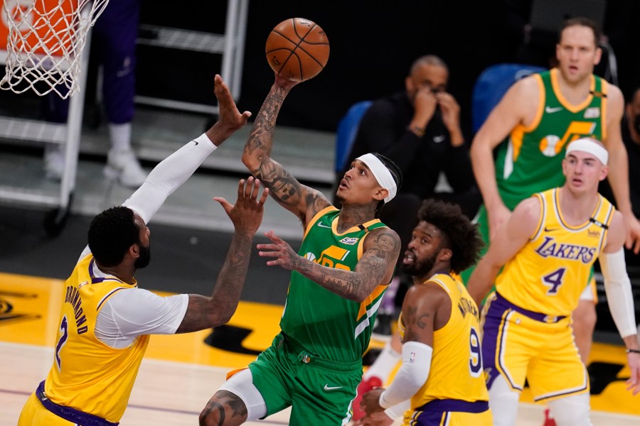 Utah Jazz guard Jordan Clarkson, center, shoots over Los Angeles Lakers center Andre Drummond, left, during the first half of an NBA basketball game in Los Angeles on April 19, 2021. (Marcio Jose Sanchez / Associated Press)