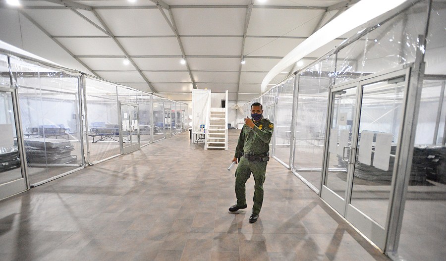 U.S. Border Patrol Agent Fidel Cabrera leads a tour of one of four living areas inside a processing facility in Yuma during an open house on April 20, 2021. (Randy Hoeft / The Yuma Sun via Associated Press)