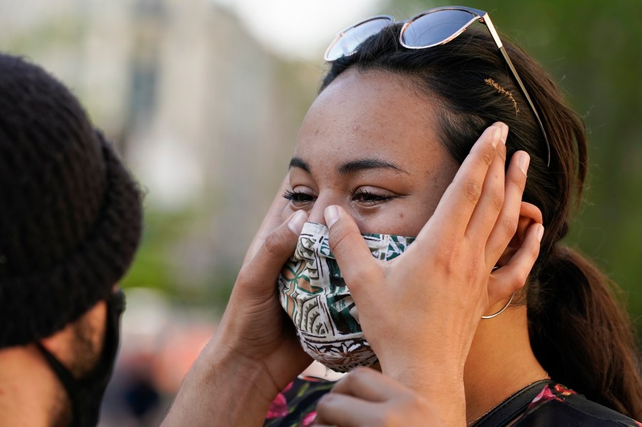 Joseph Ravago wipes tears from the eyes of Kamaile Elderts on April 20, 2021, in Washington, after the guilty verdict was read in Minneapolis in the murder trial against former Minneapolis police officer Derek Chauvin. (Alex Brandon / Associated Press)