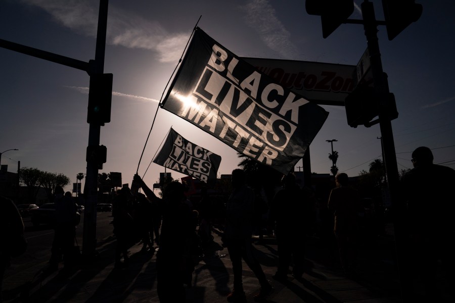 People hold Black Lives Matter flags at the intersection of Florence and Normandie avenues, on April 20, 2021, in Los Angeles, after a guilty verdict was announced at the trial of former Minneapolis police Officer Derek Chauvin for the 2020 death of George Floyd. (AP Photo/Jae C. Hong)