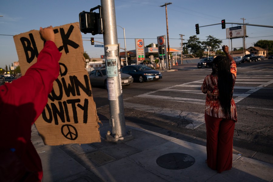 Joyce Robertson, right, clenches her fist at the intersection of Florence and Normandie Avenues in Los Angeles, on April 20, 2021, after a guilty verdict was announced at the trial of former Minneapolis police Officer Derek Chauvin for the 2020 death of George Floyd. (AP Photo/Jae C. Hong)