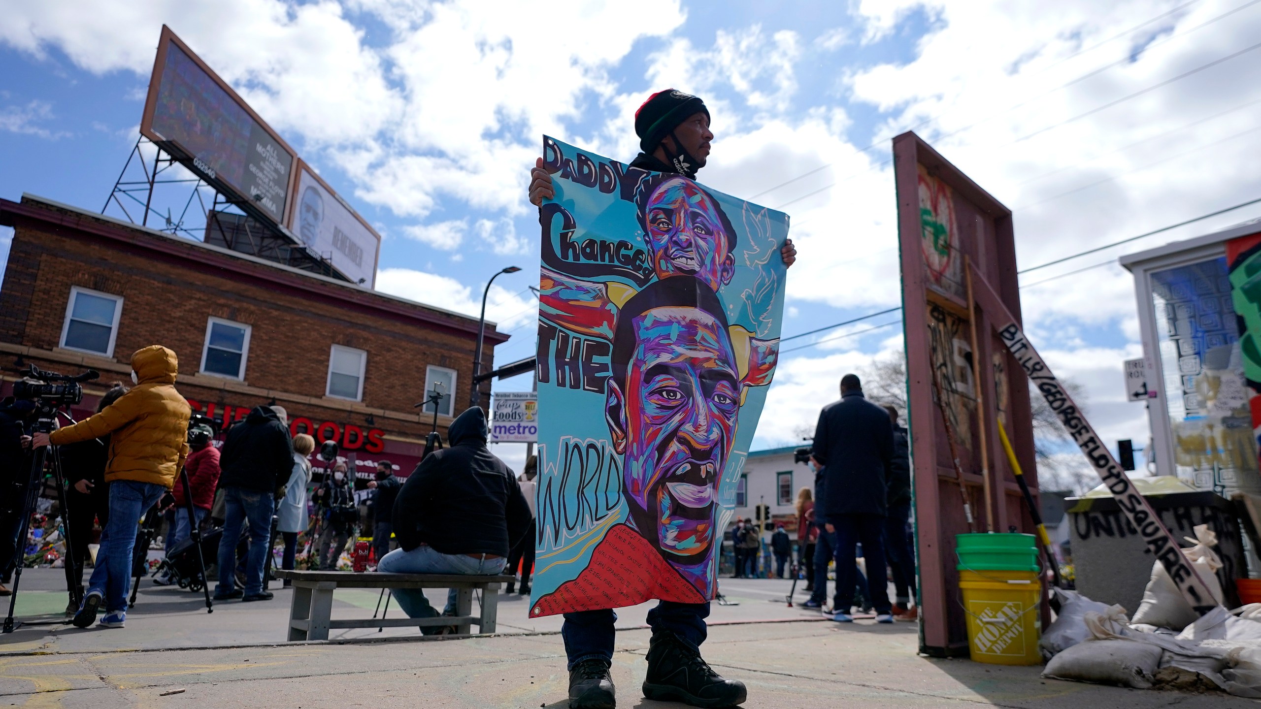 A man holds a sign at George Floyd Square, Wednesday, April 21, 2021, in Minneapolis, a day after former Minneapolis police Officer Derek Chauvin was convicted on all counts for the 2020 death of Floyd. (AP Photo/Julio Cortez)