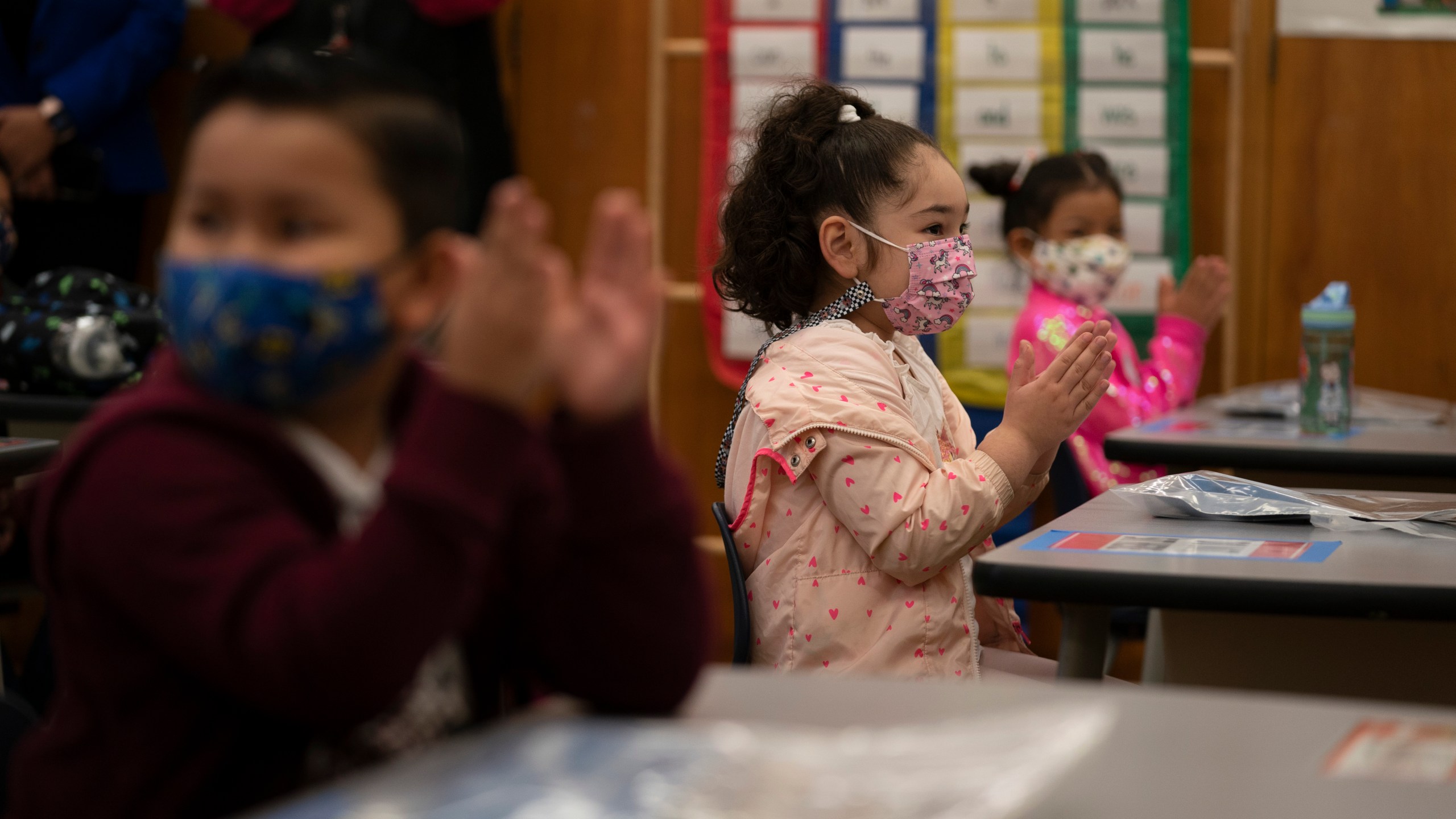 First graders applaud while listening to their teacher in a classroom on the first day of in-person learning at Heliotrope Avenue Elementary School in Maywood on April 13, 2021. (Jae C. Hong / Associated Press)