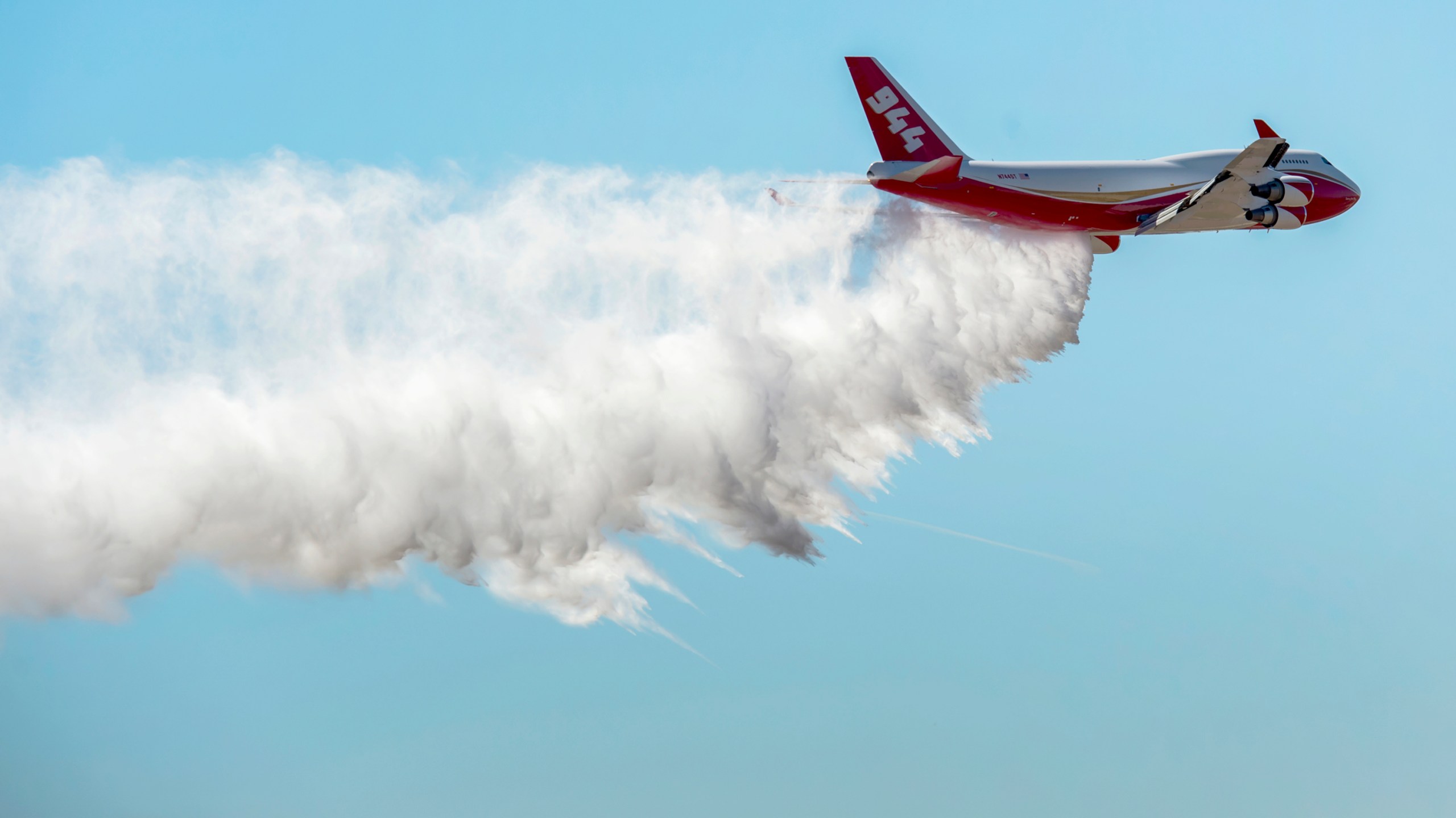 A Boeing 747-400 Global SuperTanker drops half a load of its 19,400-gallon capacity during a ceremony at Colorado Springs, Colo., on May 5, 2016. (Christian Murdock / The Gazette via Associated Press)