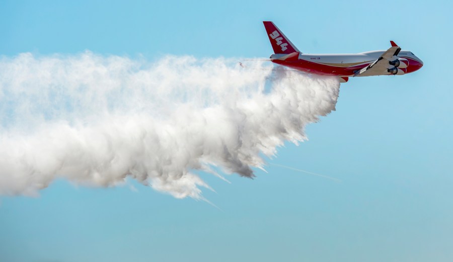 A Boeing 747-400 Global SuperTanker drops half a load of its 19,400-gallon capacity during a ceremony at Colorado Springs, Colo., on May 5, 2016. (Christian Murdock / The Gazette via Associated Press)