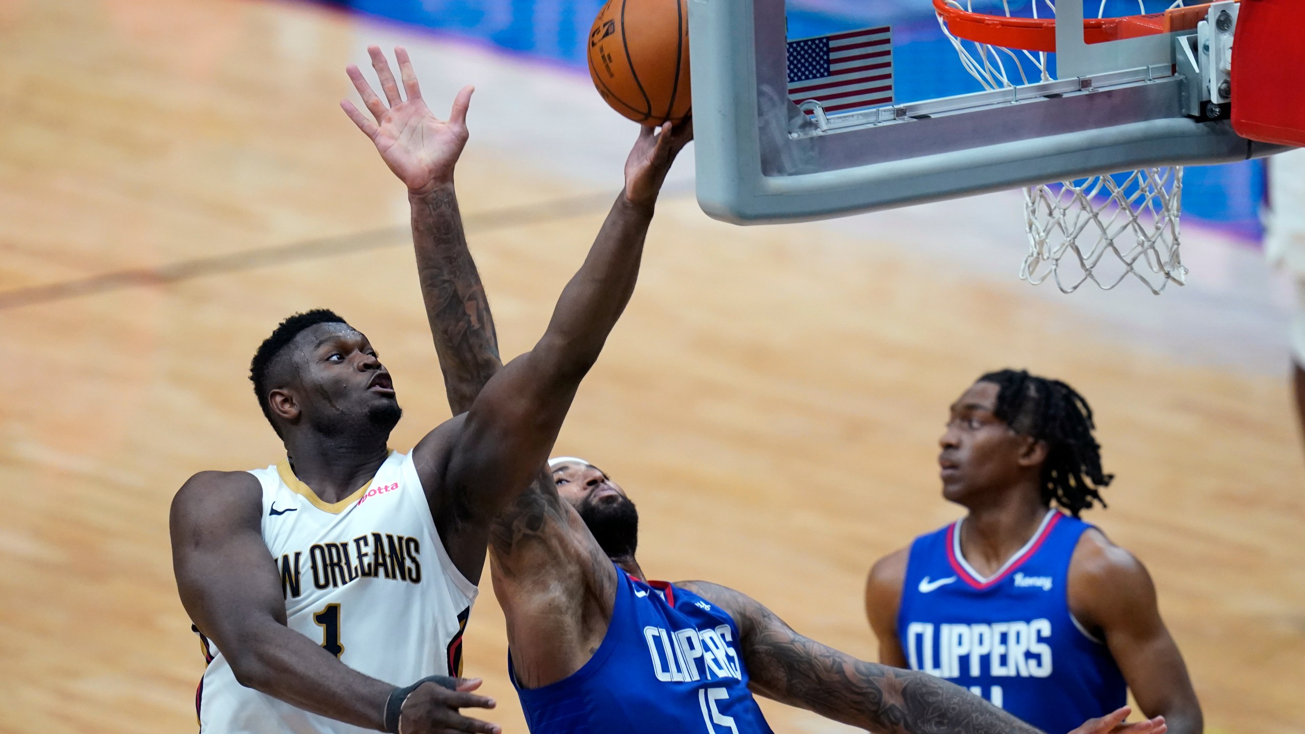 New Orleans Pelicans forward Zion Williamson (1) goes to the basket against LA Clippers center DeMarcus Cousins (15) in the second half of an NBA basketball game in New Orleans on April 26, 2021. (Gerald Herbert / Associated Press)