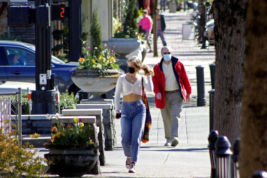 In this April 11, 2021, file photo, residents wearing masks walk in downtown Lake Oswego, Oregon. (AP Photo/Gillian Flaccus, File)