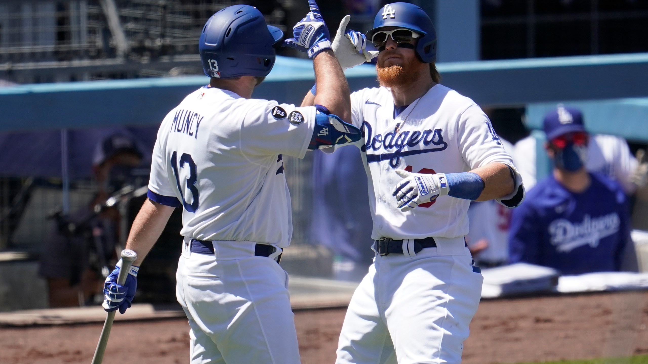 Los Angeles Dodgers' Justin Turner, right, celebrates his solo home run with Max Muncy during the third inning of a baseball game against the Cincinnati Reds in Los Angeles on April 28, 2021. (Marcio Jose Sanchez / Associated Press)