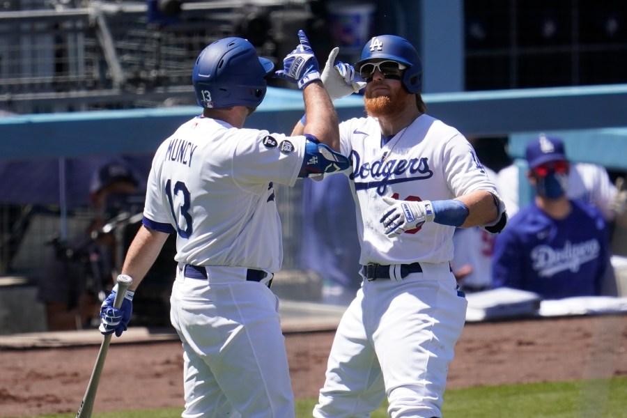 Los Angeles Dodgers' Justin Turner, right, celebrates his solo home run with Max Muncy during the third inning of a baseball game against the Cincinnati Reds in Los Angeles on April 28, 2021. (Marcio Jose Sanchez / Associated Press)