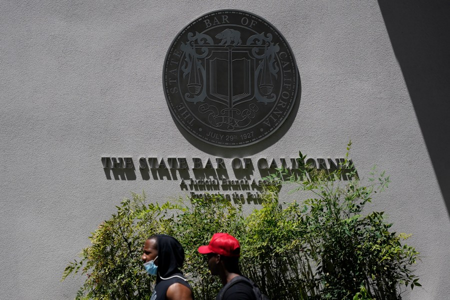 People walk past the entrance of The State Bar of California office Thursday, April 29, 2021, in Los Angeles. (AP Photo/Ashley Landis)