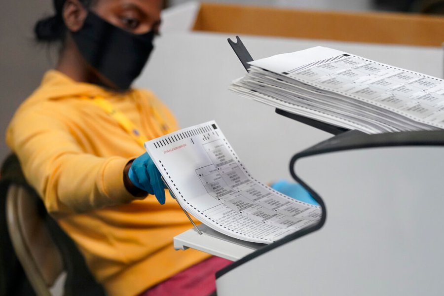 In this Nov. 5, 2020, file photo, a county election worker scans mail-in ballots at a tabulating area at the Clark County Election Department in Las Vegas. (AP Photo/John Locher, File)