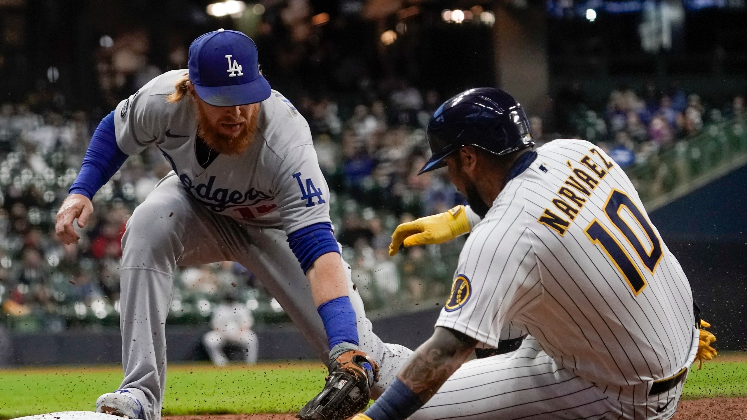 Los Angeles Dodgers' Justin Turner tags out Milwaukee Brewers' Omar Narvaez at first during the first inning of a baseball game Friday, April 30, 2021, in Milwaukee. (AP Photo/Morry Gash)