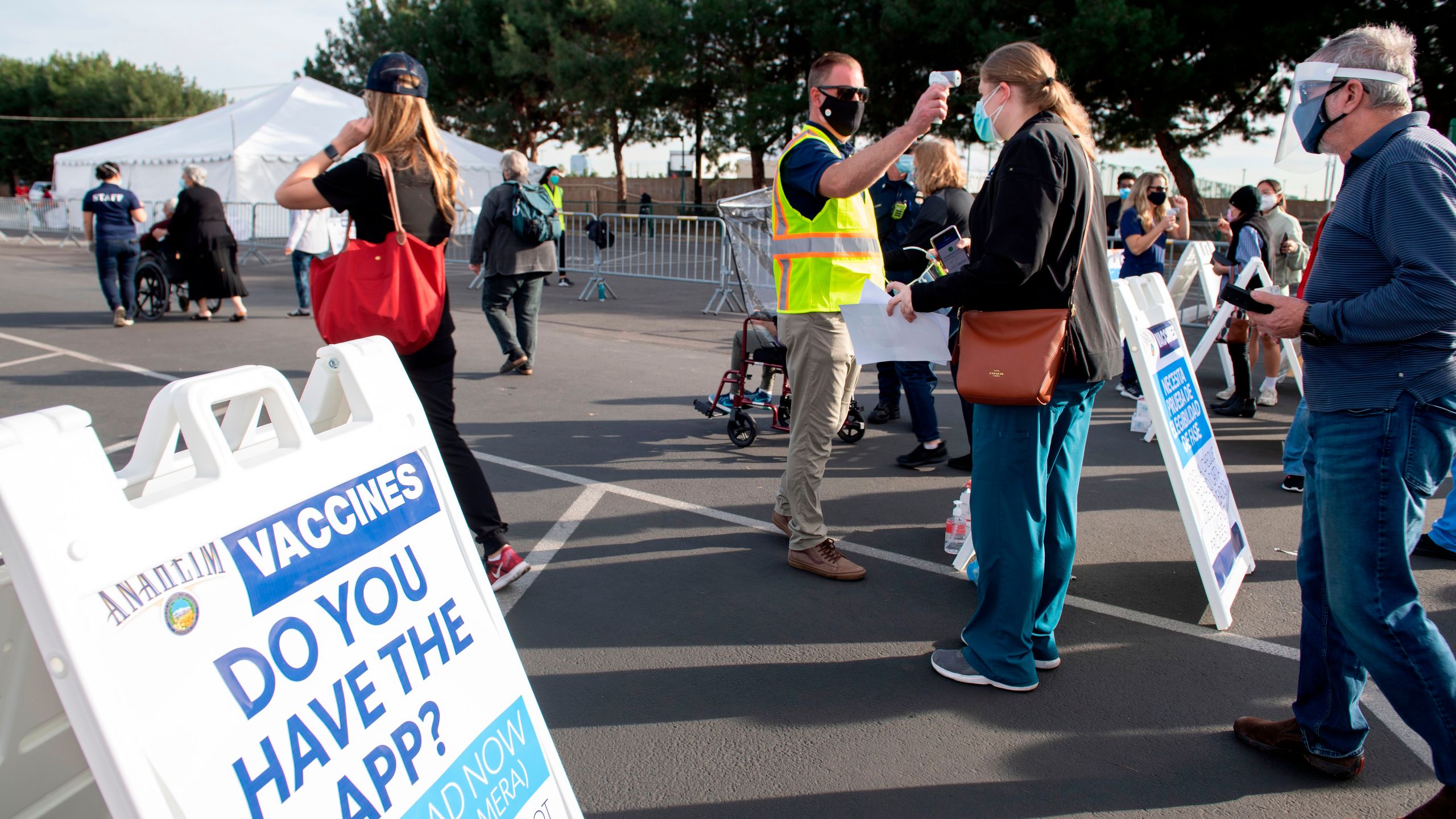 People have their temperature checked as they arrive at a Disneyland parking lot to receive COVID-19 vaccines on Jan. 13, 2021, in Anaheim. (VALERIE MACON/AFP via Getty Images)