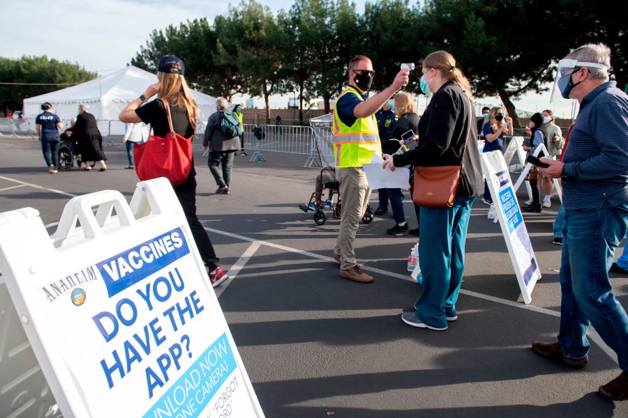 People have their temperature checked as they arrive at a Disneyland parking lot to receive COVID-19 vaccines on Jan. 13, 2021, in Anaheim. (VALERIE MACON/AFP via Getty Images)