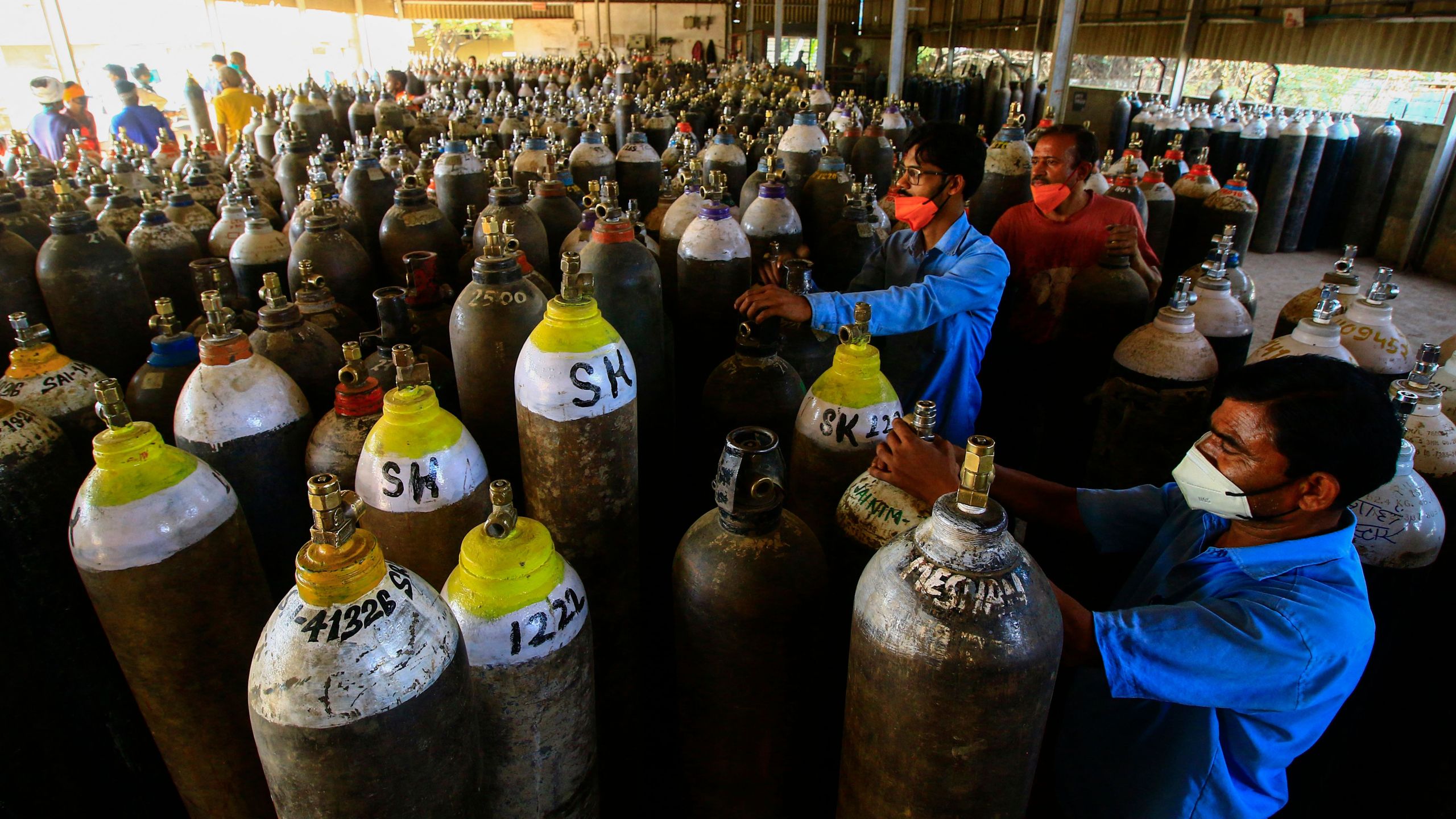 Workers prepare to fill medical oxygen cylinders for hospital use on COVID-19 patients on the outskirts of Jabalpur, India on April 18, 2021. (Uma Shankar/AFP via Getty Images)