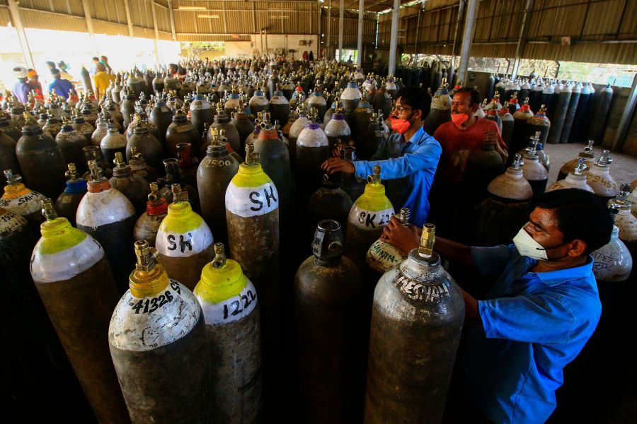 Workers prepare to fill medical oxygen cylinders for hospital use on COVID-19 patients on the outskirts of Jabalpur, India on April 18, 2021. (Uma Shankar/AFP via Getty Images)