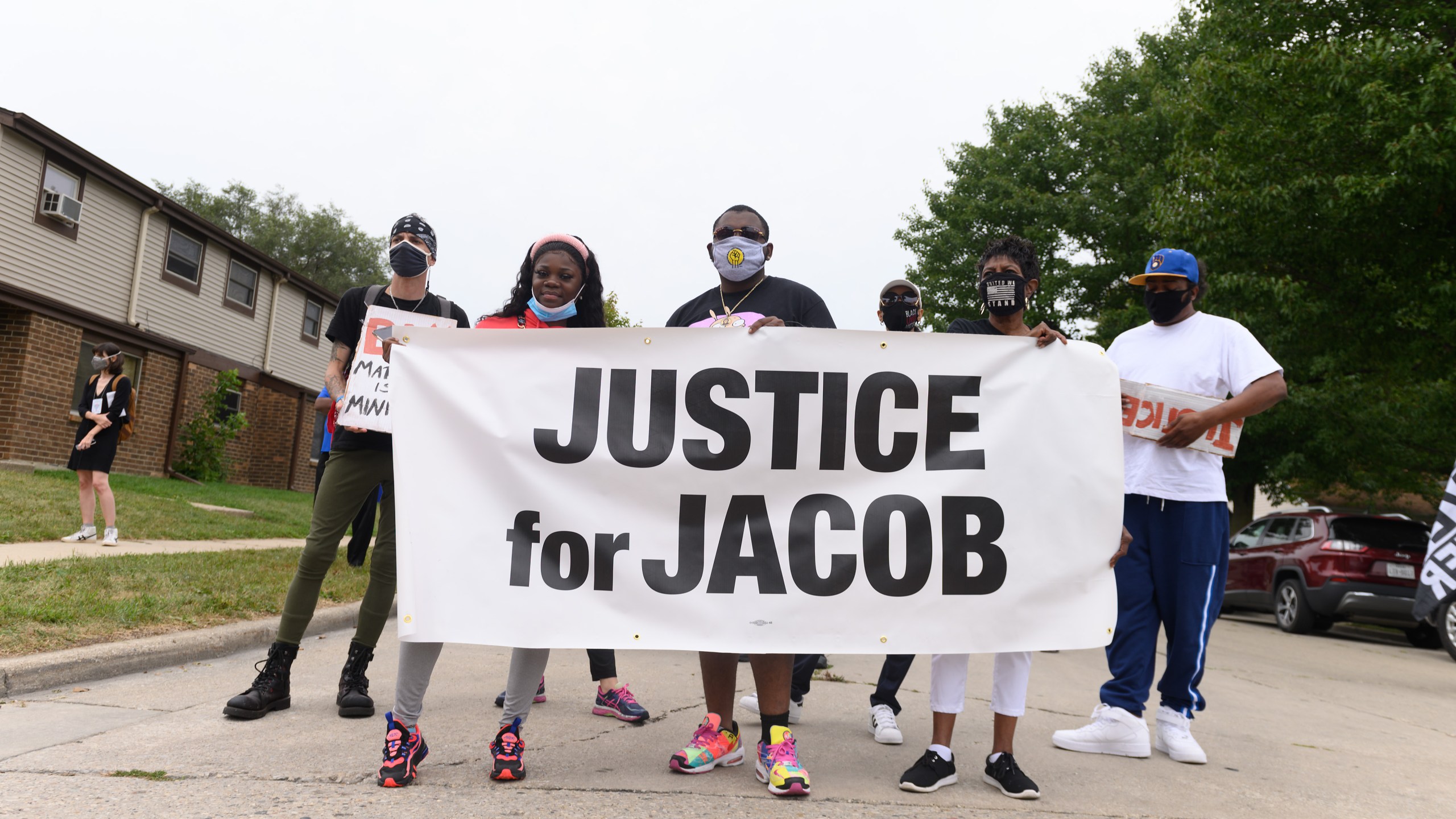 Protesters hold a banner during a community celebration and call for justice for Jacob Blake as grassroots group MoveOn flies an airplane banner and drives a mobile billboard calling on voters to "Reject Trump's Violence," in response to Donald Trump's visit on Sept. 1, 2020 in Kenosha, Wisconsin. (Daniel Boczarski/Getty Images for MoveOn)