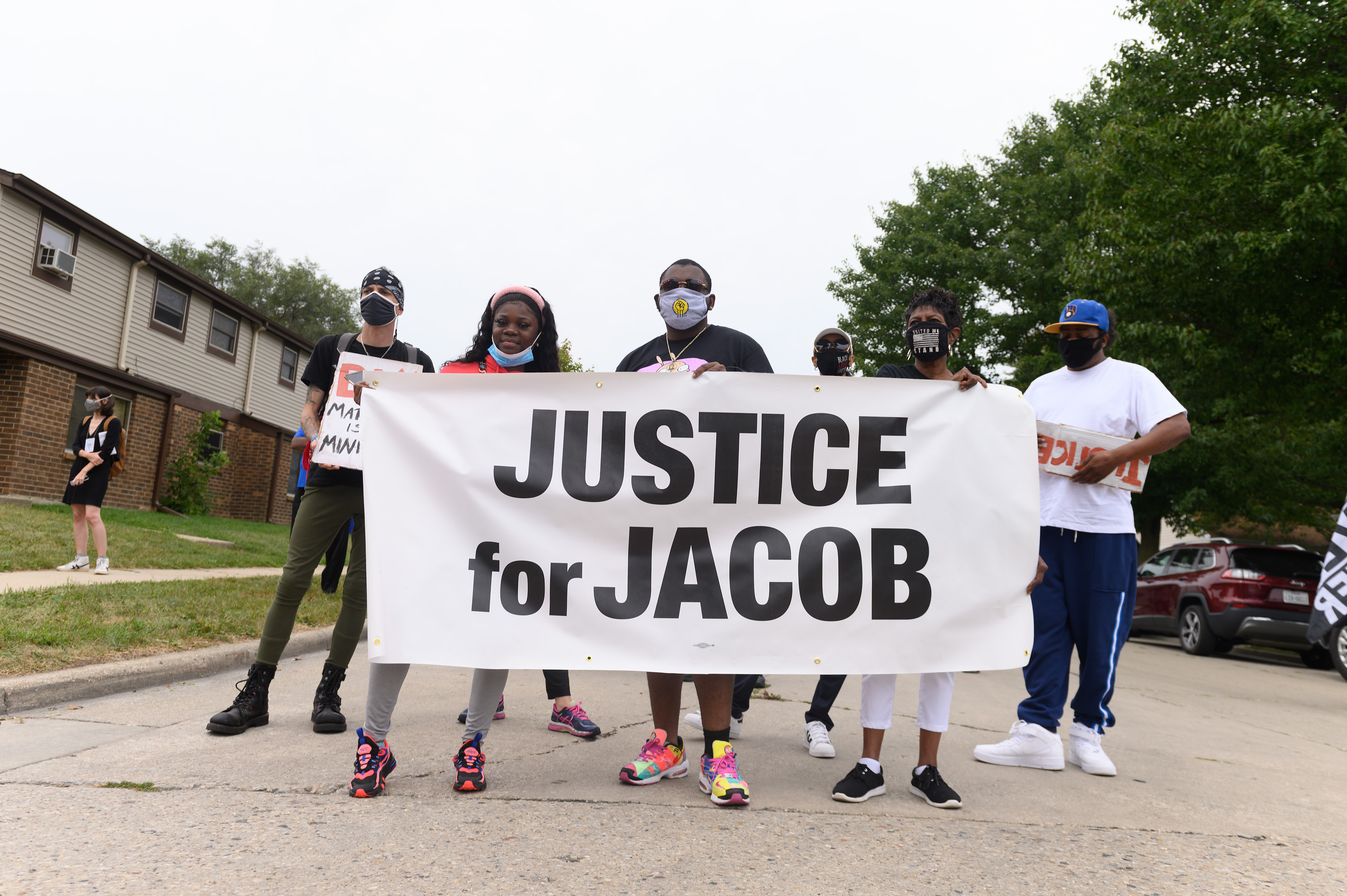 Protesters hold a banner during a community celebration and call for justice for Jacob Blake as grassroots group MoveOn flies an airplane banner and drives a mobile billboard calling on voters to "Reject Trump's Violence," in response to Donald Trump's visit on Sept. 1, 2020 in Kenosha, Wisconsin. (Daniel Boczarski/Getty Images for MoveOn)