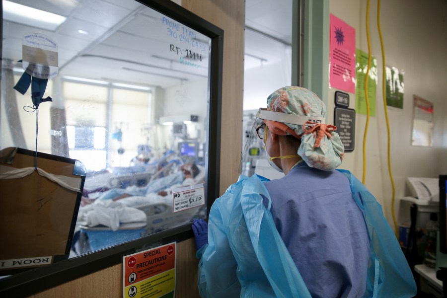 Certified registered nurse anesthetist Lisa Taft, who normally works in operating rooms, enters a room to care for COVID-19 patients in a makeshift intensive care unit at Harbor-UCLA Medical Center in Torrance on Jan. 21, 2021. (Mario Tama / Getty Images)