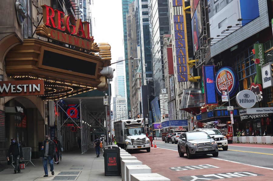 People walk past the Regal Cinemas in Times Square on March 24, 2021 in New York City. (Michael M. Santiago/Getty Images)