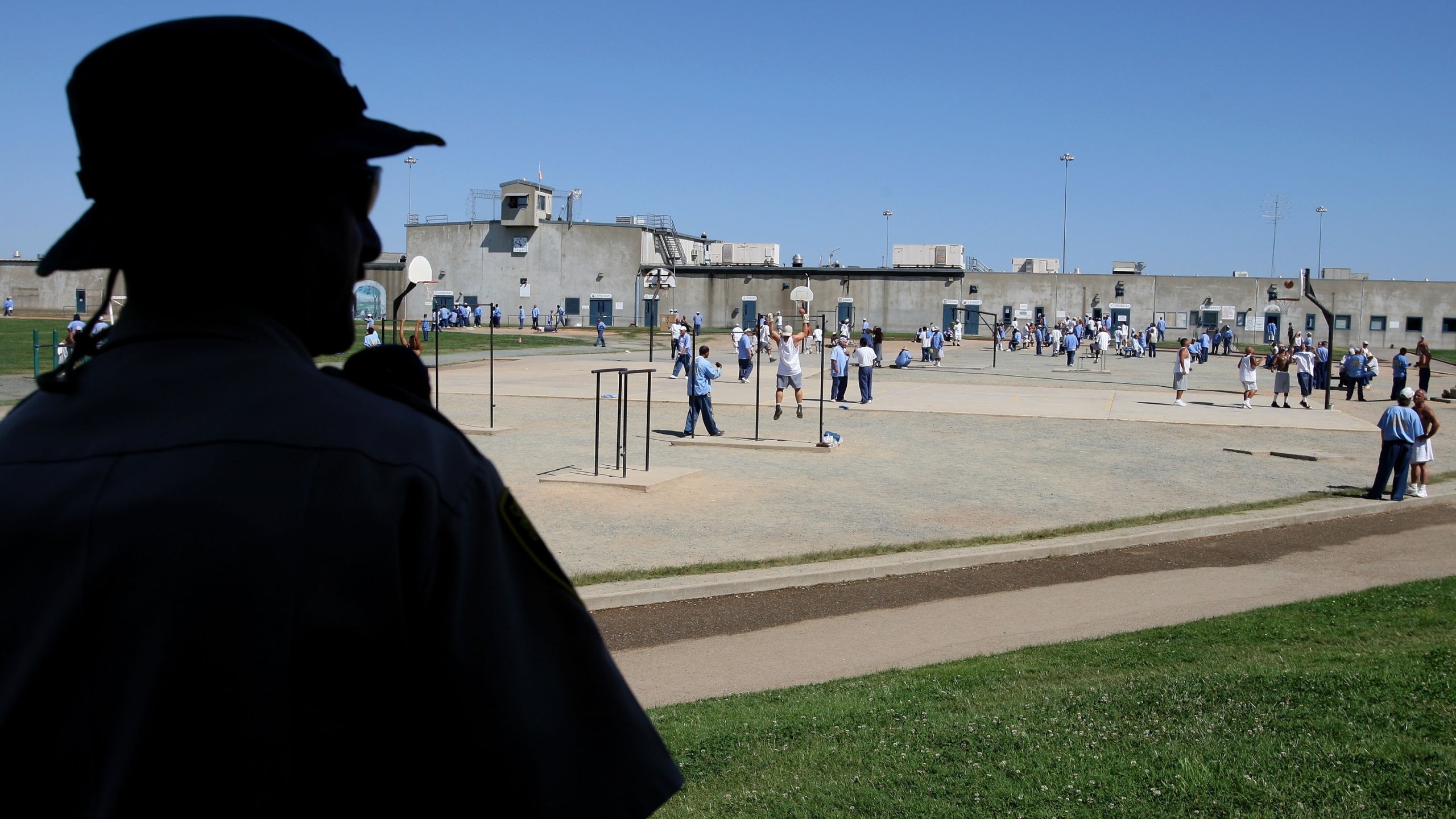 A California Department of Corrections officer looks on as inmates at the Mule Creek State Prison exercise in the yard August 28, 2007, in Ione. (Justin Sullivan/Getty Images)